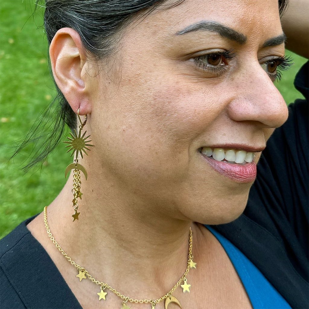 Long brass dangle earrings with sun, moon and stars on model