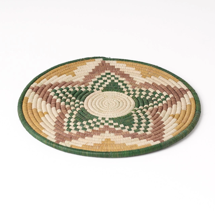 Round hand woven trivet with star design in green, gold, tan and brown
