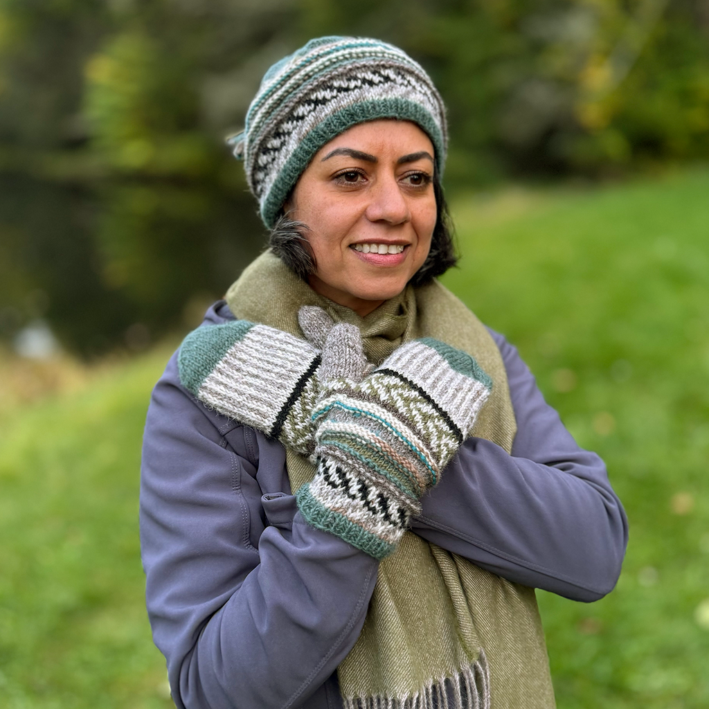Handknit wool mittens and hat with green, brown, cream colored design on model