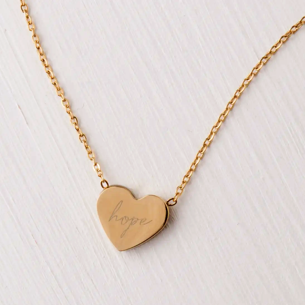 Gold heart necklace with the word hope engraved on it