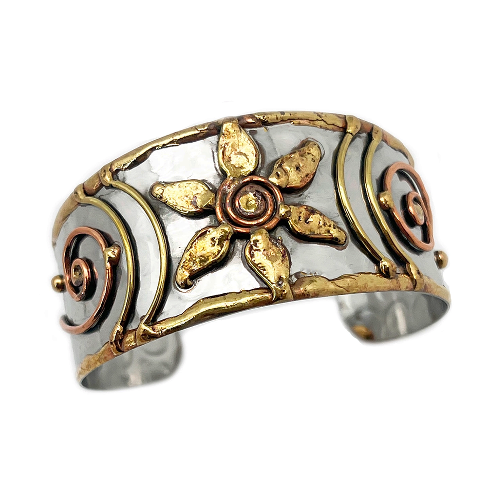 Wide silver, brass and copper cuff bracelet with flower and spiral accents.