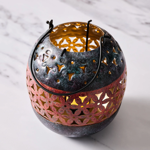 Painted iron lantern for tea lights with floral pattern.