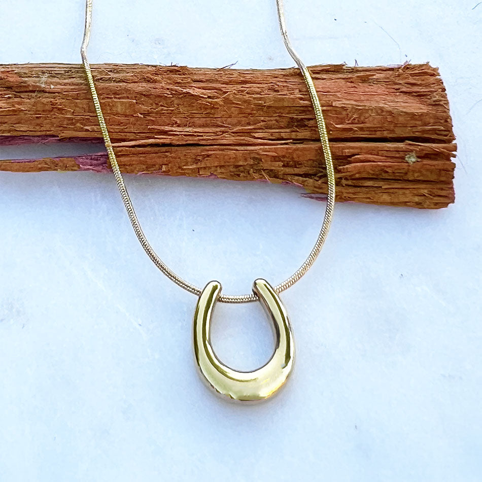 Fair trade horseshoe necklace handmade by survivors of human trafficking