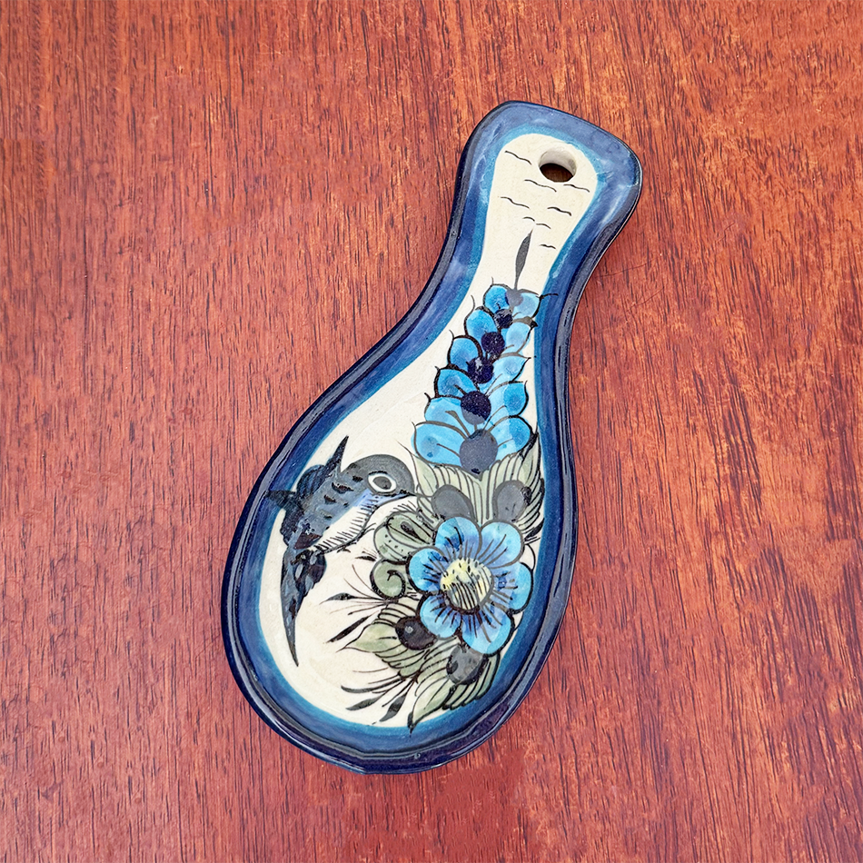 Ceramic spoon rest with blue painted hummingbird design.