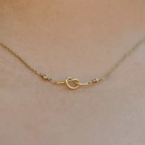 Fair trade brass knot necklace handmade by survivors of human trafficking.