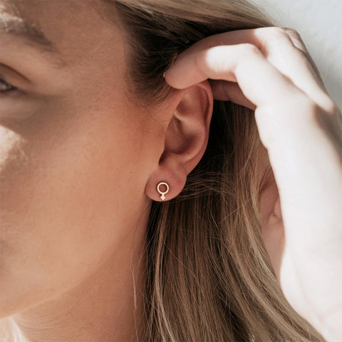 Women's symbol stud earrings handmade by survivors of human trafficking.