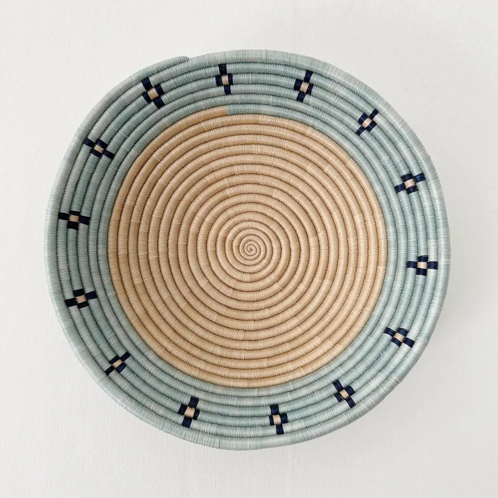 Fair trade basket with sisal and sweetgrass handmade by women artisans in Rwanda, tan center with blue rim and black accent.