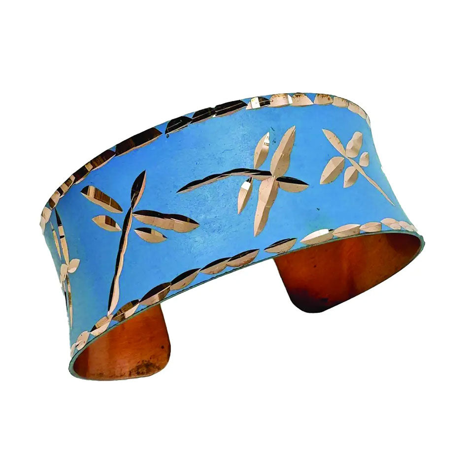 Fair trade copper cuff bracelet with dragonfly design on blue.