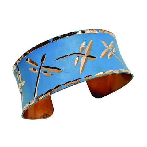 Fair trade copper cuff bracelet with dragonfly design on blue.