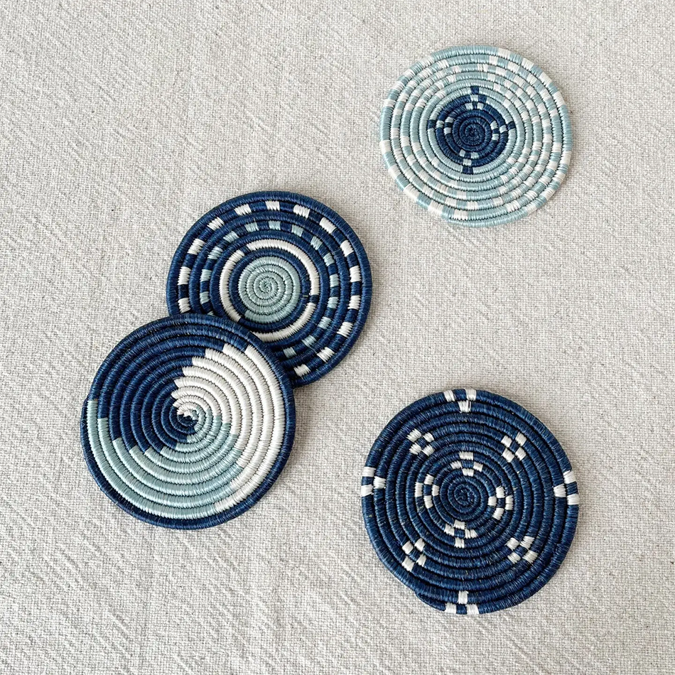 Fair trade handwoven coasters made in Rwanda out of sweetgrass.  Set of four in blue and white designs.