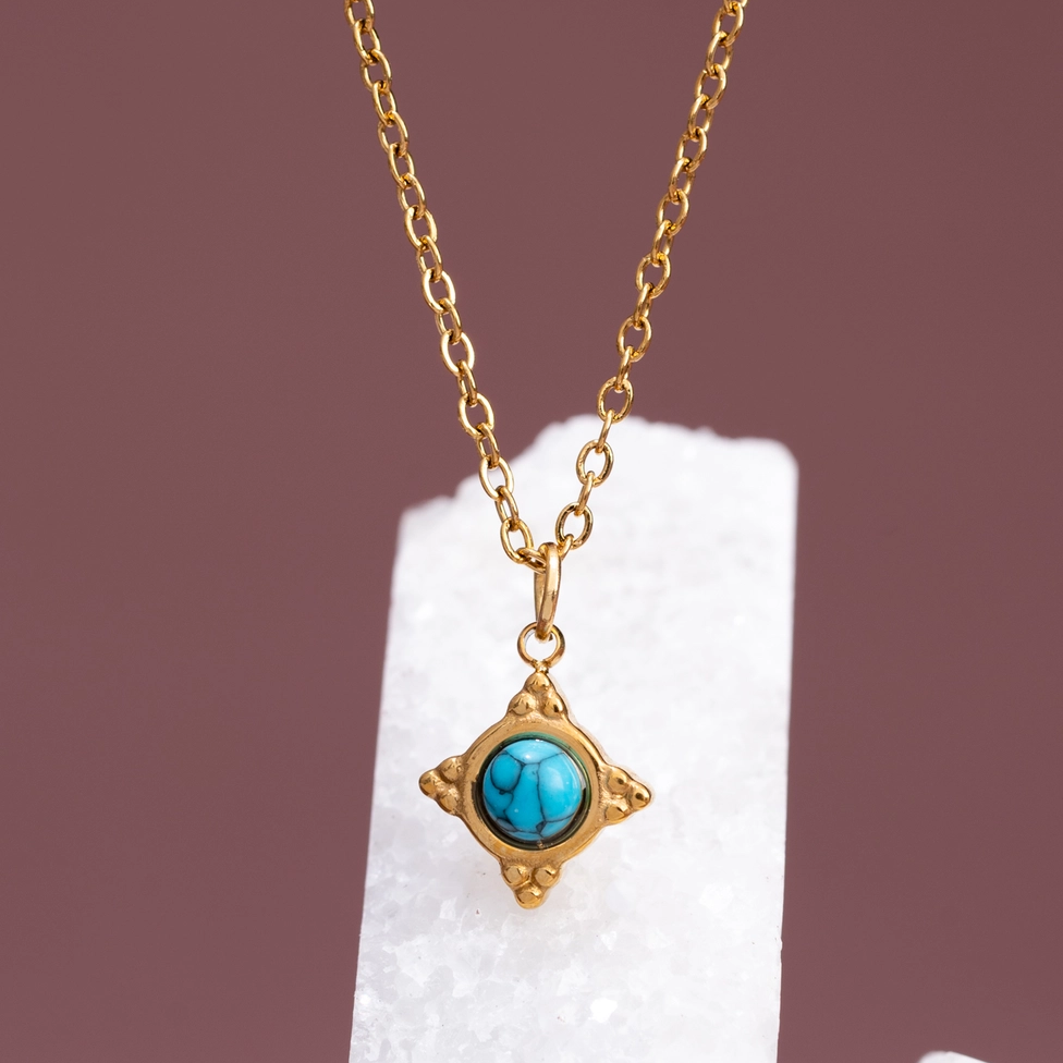 Gold-plated tiny compass necklace with turquoise stone in the center. 
