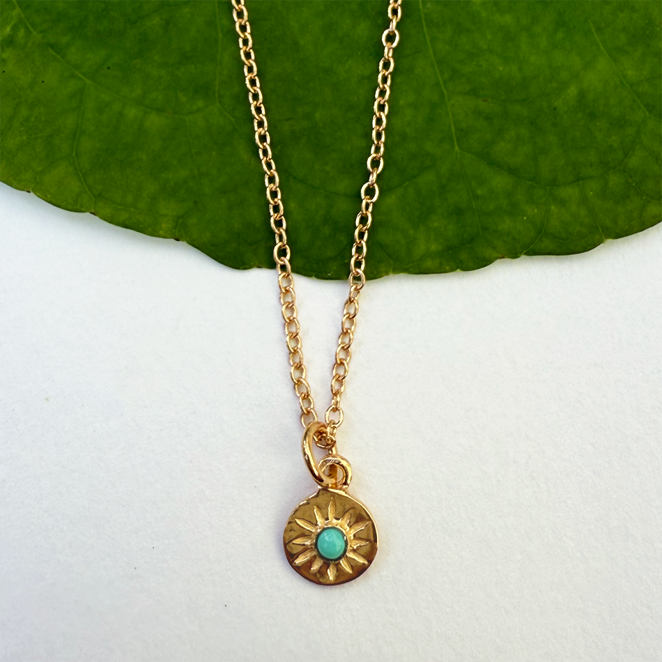 Fair trade tiny gold-plated compass necklace with turquoise stone.