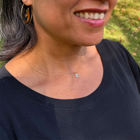 Fair trade tiny gold-plated compass necklace with turquoise stone.