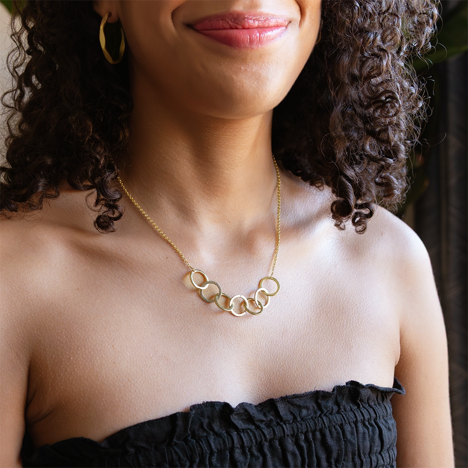 Necklace with 7 interlocking silver and gold circle pendants.