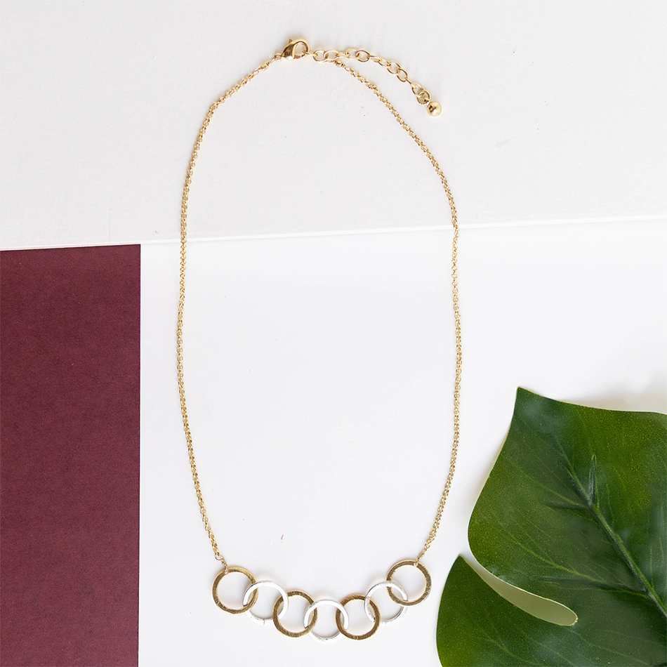 Necklace with 7 interlocking silver and gold circle pendants.