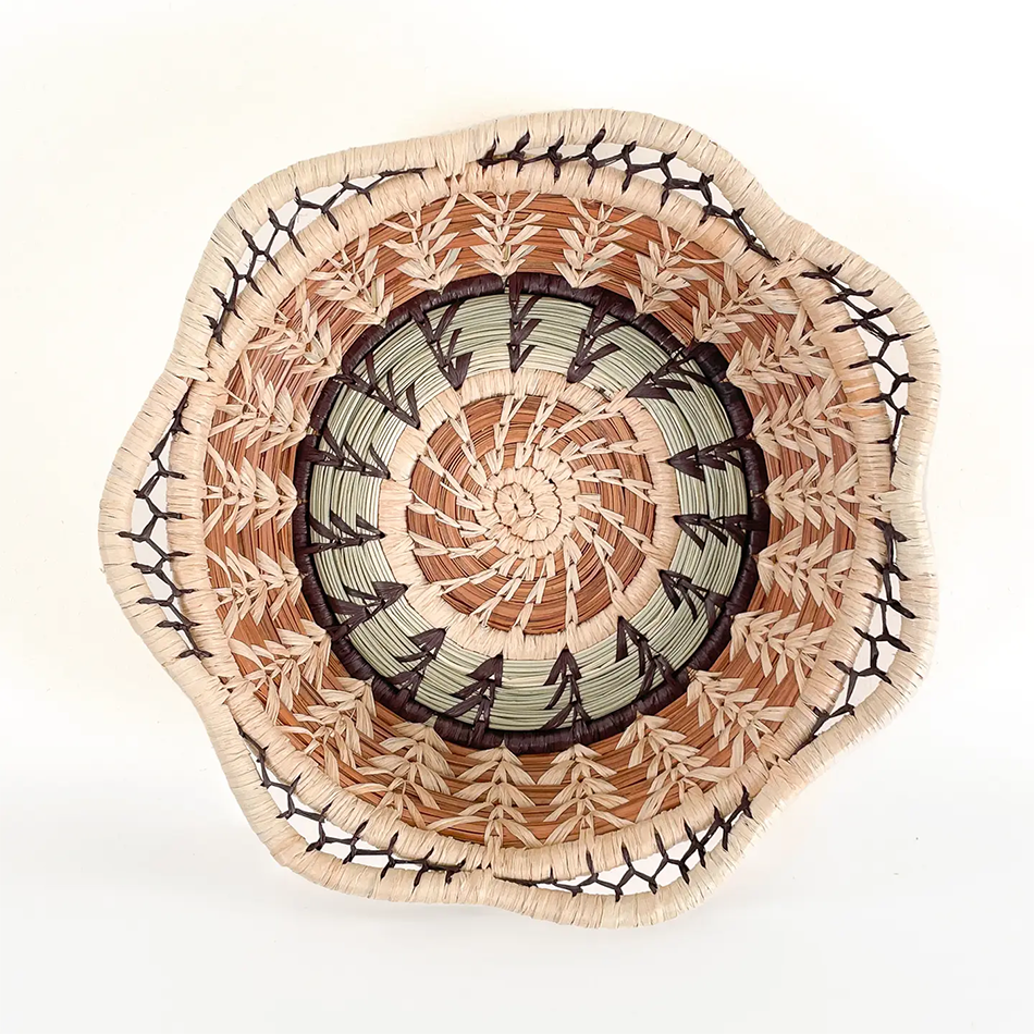 Small pine needle basket round with decorative design, tan and light green.
