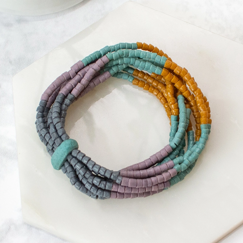 Glass bracelet with several strands of beads in orange, purple and blue