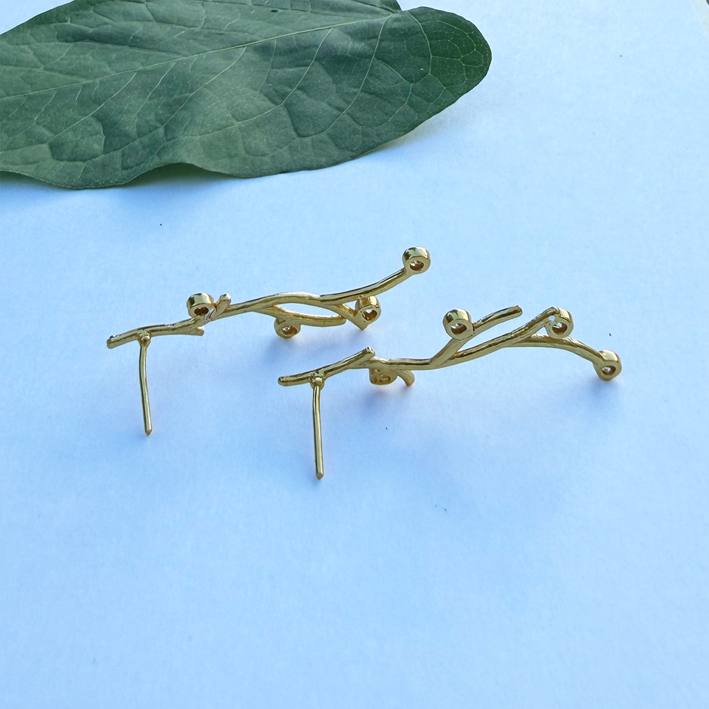 Gold post earrings with branches and zircon stones on side