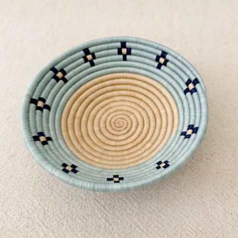 Fair trade basket with sisal and sweetgrass handmade by women artisans in Rwanda, tan center with blue rim and black accent.