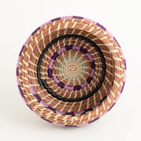 Fair trade small pine needle basket with purple and green accents.