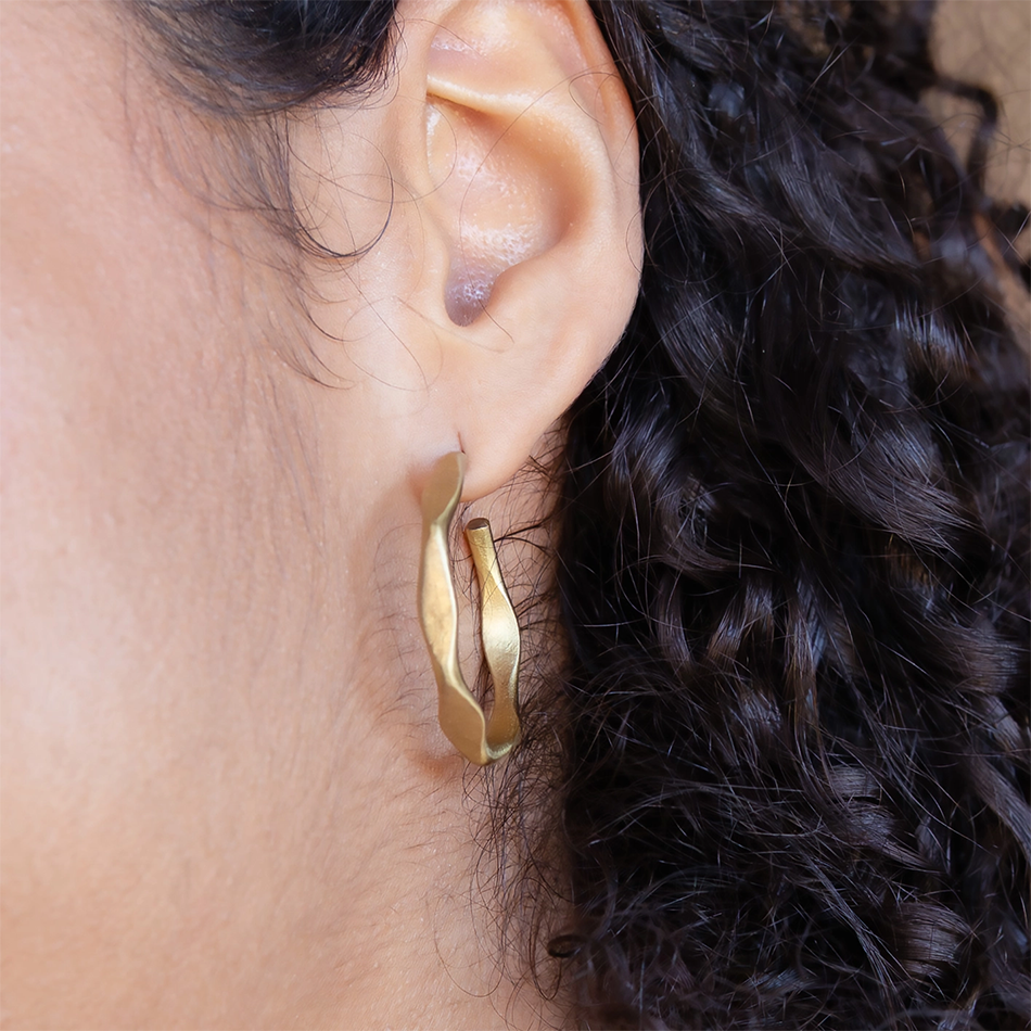 Gold-plated hoop stud-style earrings with unique shape.