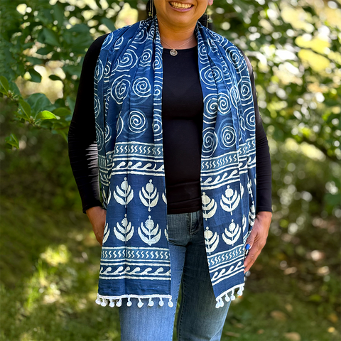 Fair trade indigo cotton scarf with spiral and flower design and pom poms.