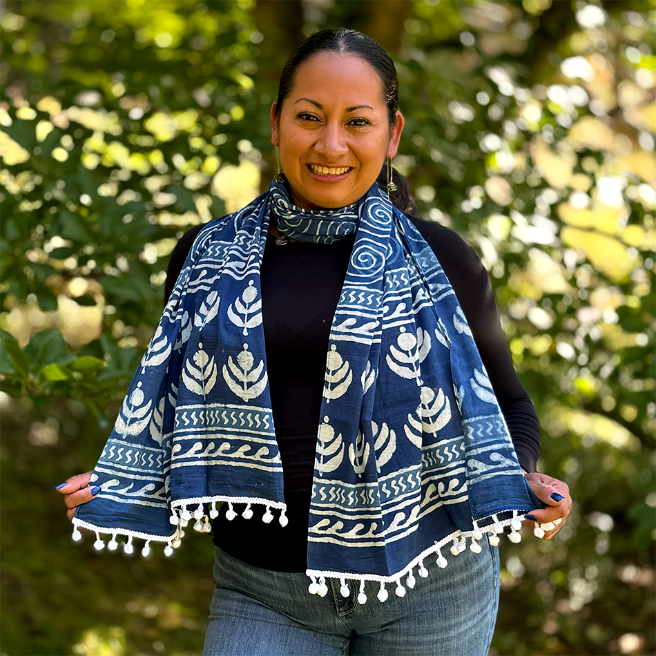 Fair trade indigo cotton scarf with spiral and flower design and pom poms.