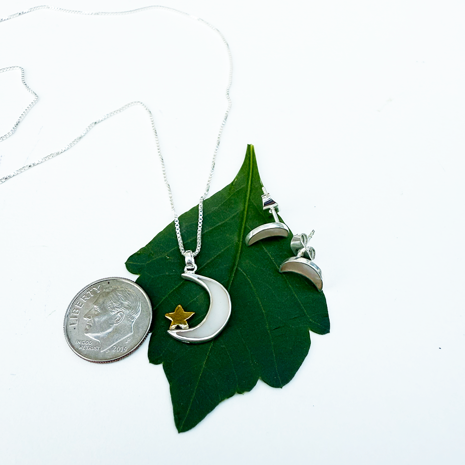 Sterling silver crescent moon and star necklace on silver box chain.