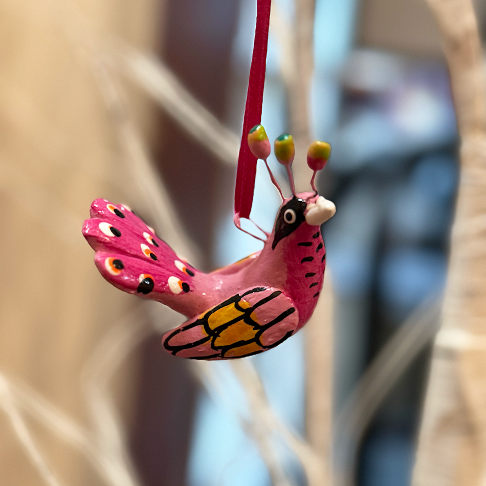 Ceramic hand-painted pink peacock ornament.