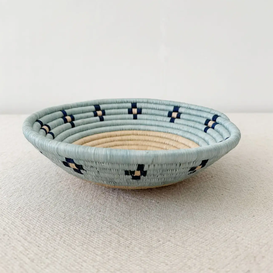 Fair trade basket with sisal and sweetgrass handmade by women artisans in Rwanda, tan center with blue rim and black accent.