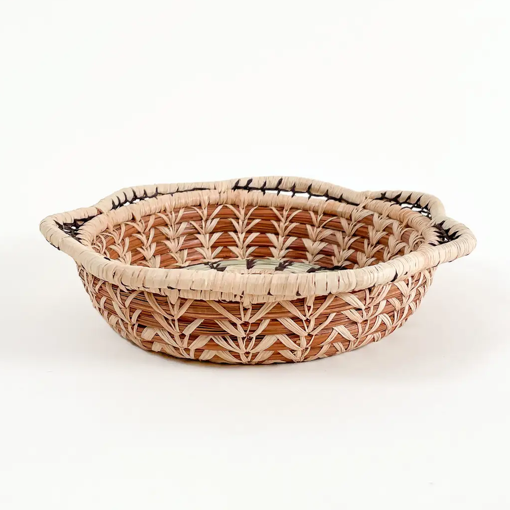 Small pine needle basket round with decorative design, tan and light green.