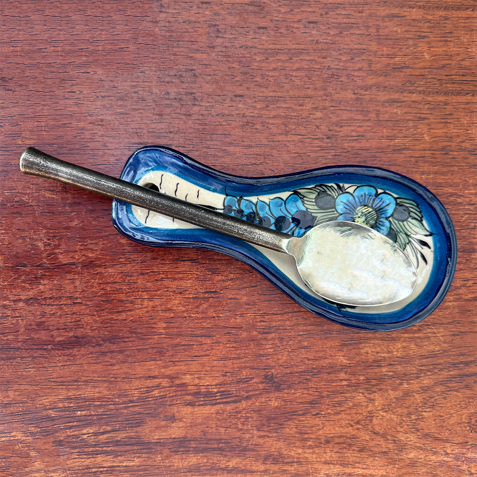 Ceramic spoon rest with blue painted hummingbird design.