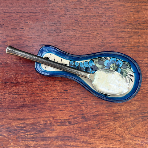 Ceramic spoon rest with blue painted hummingbird design.