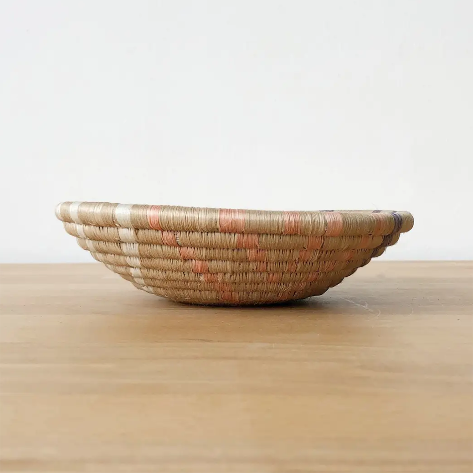 Fair trade sweetgrass basket handmade in Rwanda, natural color with colored accents.  Side view