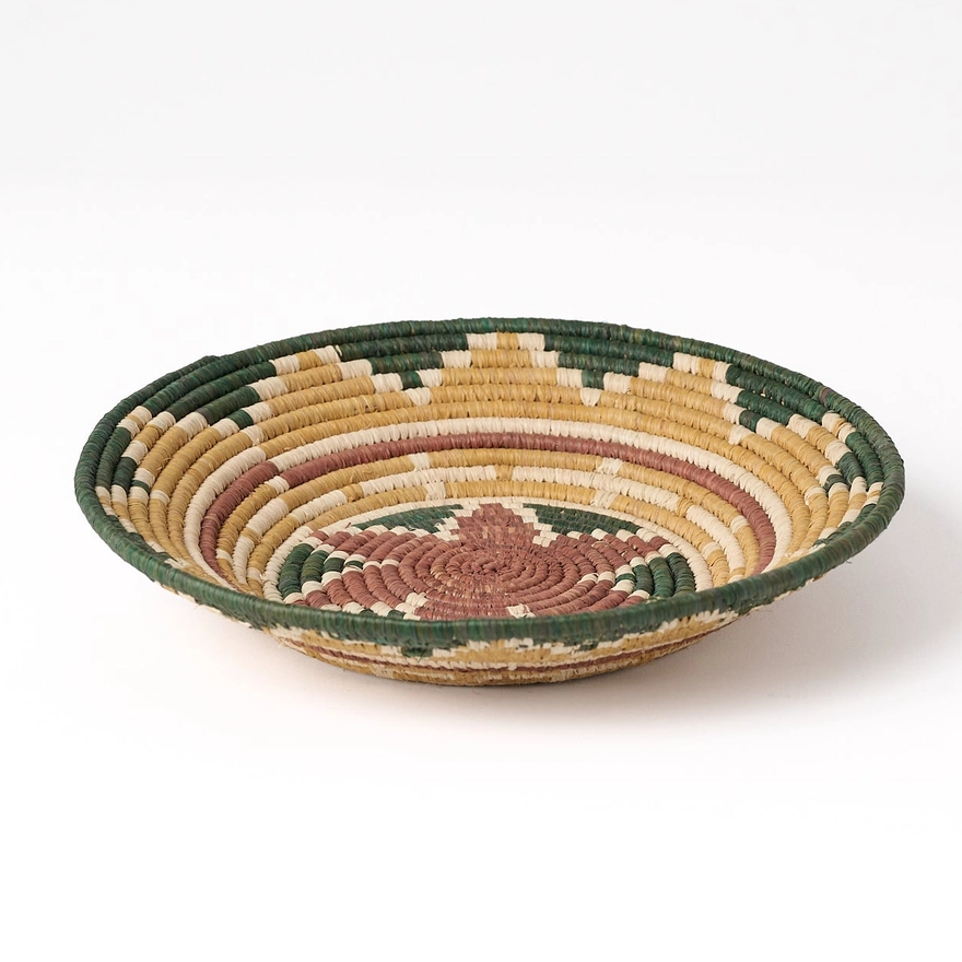 Round banana fiber basket with star petal design in brown, tan and green